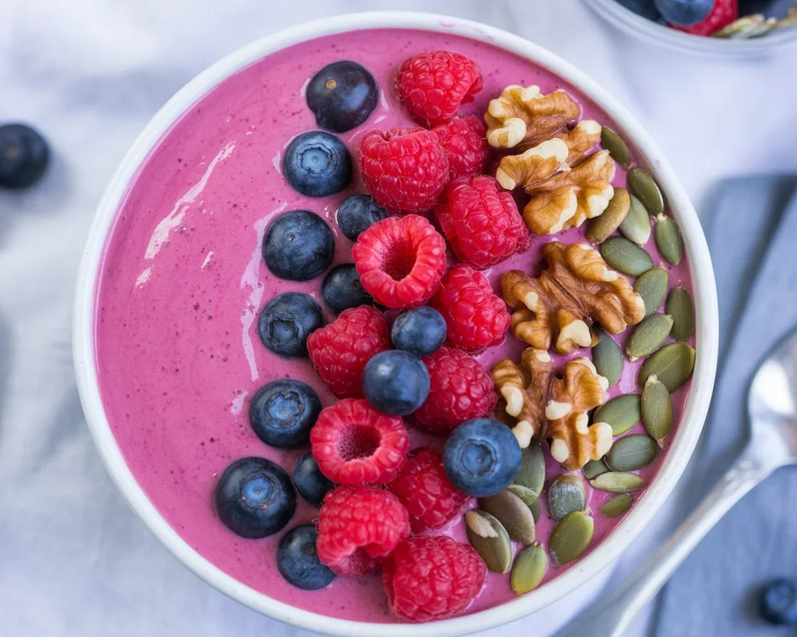 Delicious keto acai bowl topped with low-carb berries and nuts, dairy-free.