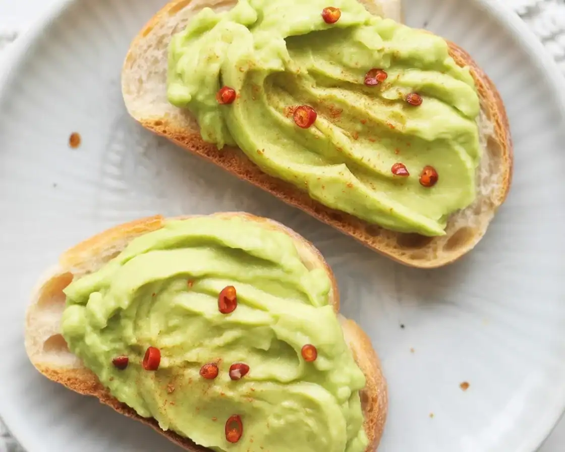 Delicious keto avocado toast topped with fresh ingredients and crispy cauliflower thins.