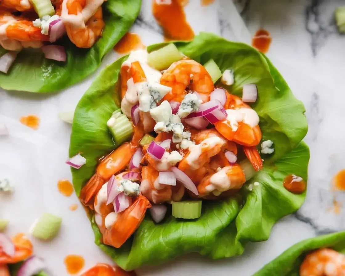 Delicious low-carb buffalo shrimp lettuce wraps topped with celery and blue cheese.